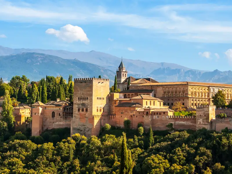 Auf Ihrer individuellen Rundreise im Mietwagen durch Andalusien haben Sie einen Panoramablick auf die Alhambra mit ihren Türmen, Mauern und Gebäuden, eingebettet in die Landschaft der Sierra Nevada.