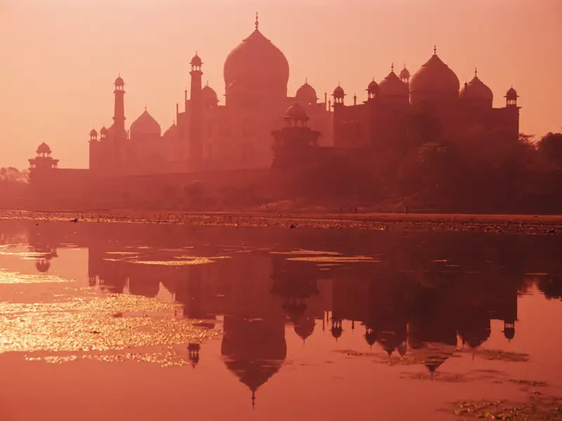 Der Höhepunkt Ihrer individuellen Reise durch Nordindien: das Taj Mahal. das sich in der Abendsonne im Yamuna-Fluss spiegelt.
