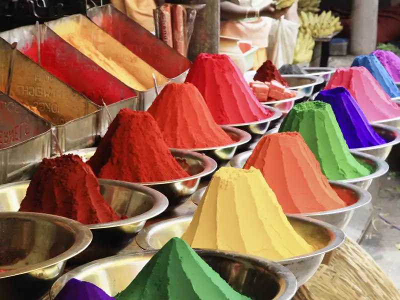 Während Sie auf Ihrer individuellen Rundreise durch Südindien über einen der zahlreichen Märkte schlendern, werden Sie immer wieder buntes Farbpulver zu ordentlichen Kegeln aufgetürmt sehen.