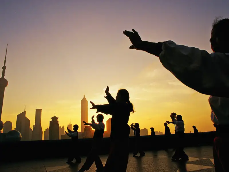 Auf Ihrer individuellen China-Rundreise sehen Sie in Shanghai am Abend vielleicht Einheimische, die am Bund Tai-Chi machen.