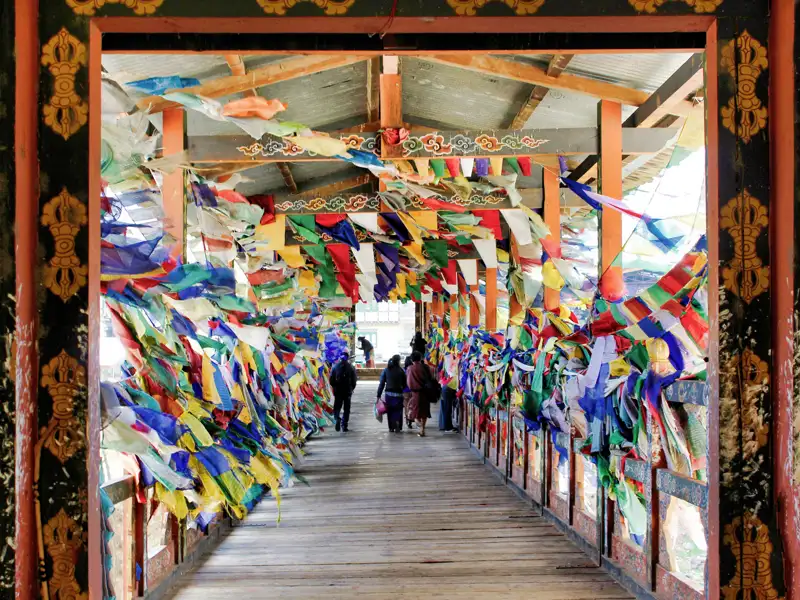 Auf Ihrer Rundreise durch Bhutan besuchen Sie zahlreiche Klöster. Bunte Gebetsfahnen weisen Ihnen den Weg zum Eingang der Klöster, so wie hier in Thimphu.