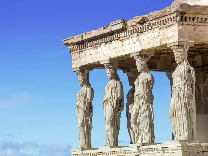 Bei Ihrer Reise in Athen besichtigen Sie unter anderem die Akropolis, wo Sie die Karyatiden sehen können, wie sie das Dach des Erechtheion-Tempels tragen.