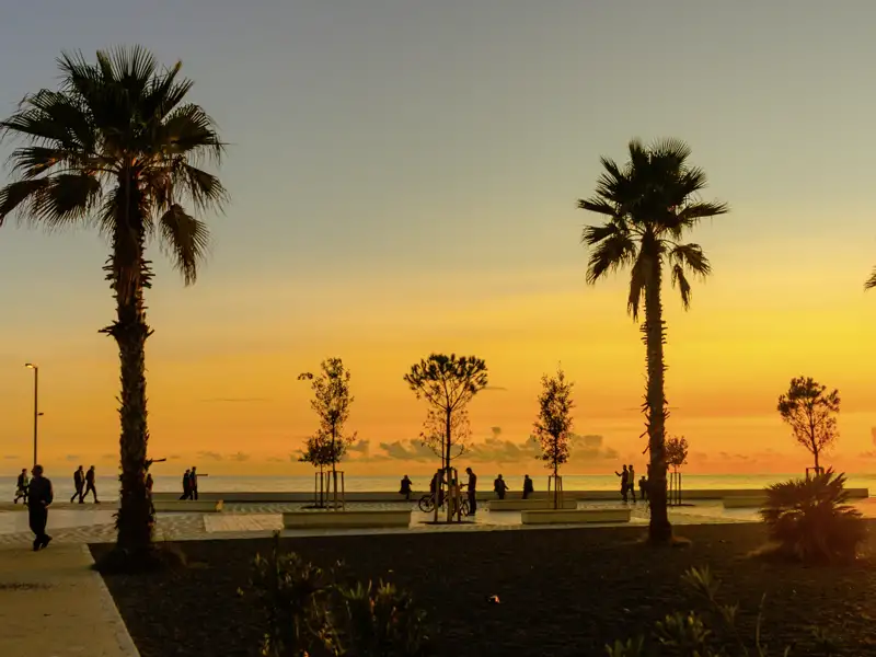 Bei unserer Rundreise genießen wir einen atemberaubenden Sonnenuntergang an der palmengesäumten Promenade von Durres an der Adriaküste.