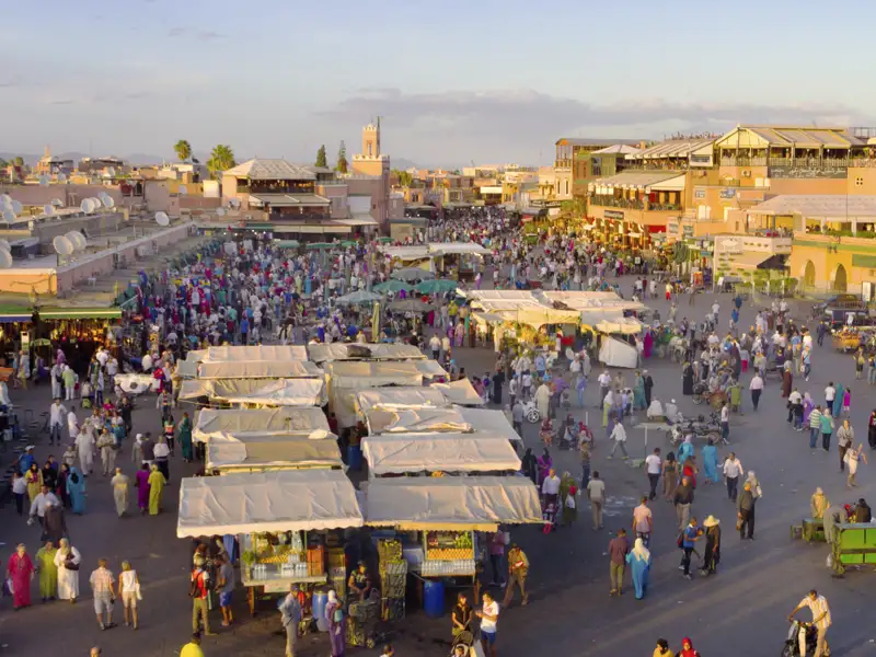Das pulsierende Zentrum Marrakeschs bildet der Marktplatz Djemaa el-Fna, auf dem sich neben Händler auch allerlei Künstler wie Wahrsager und Schlangenbeschwörer dem Publikum präsentieren.