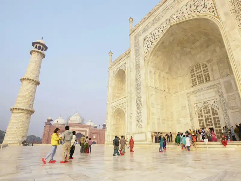 Unsere Reisegruppe besichtigt das Taj Mahal in Agra, ein im Reiseverlauf inkludiertes UNESCO-Weltkulturerbe, mit Blick auf die Fassade und ein Minarett.
