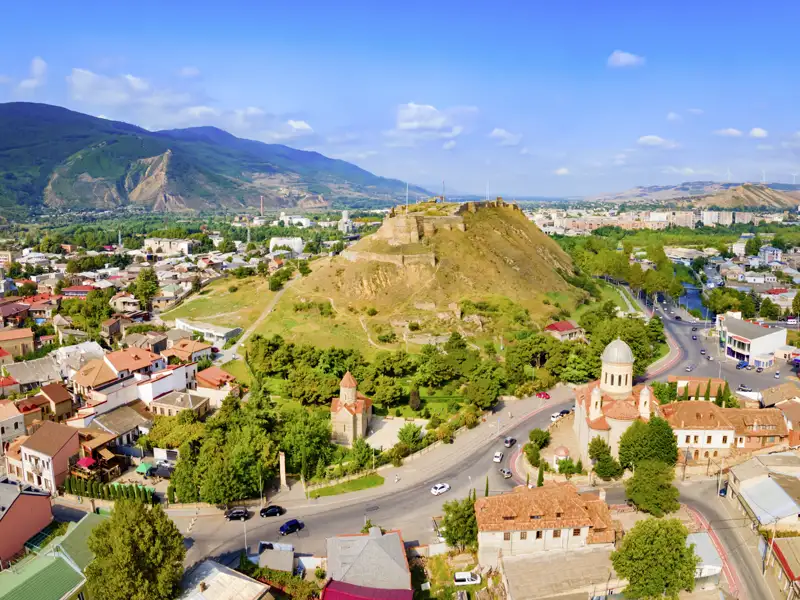 Auf der Rundreise mit MarcoPolo durch Georgien die Stadt Gori mit ihrer Festung und der Altstadt vor dem Kaukasus entdecken.