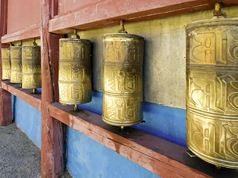 Goldene Gebetsmühlen mit religiösen Symbolen