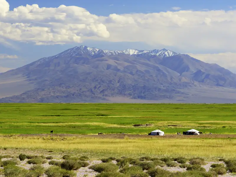 Jurten in einer malerischen Umgebung mit Bergen und Wolken