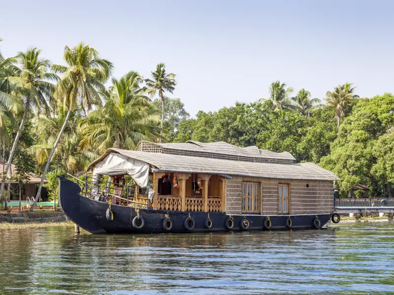 Traditionelles Hausboot steht am Ufer in den Backwaters von Kerala.