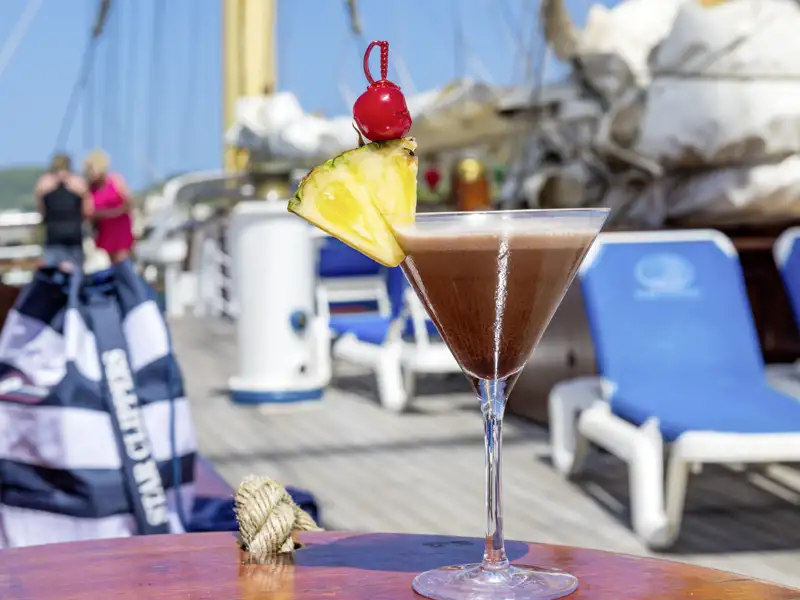 Fruchtiger Cocktail auf dem Holztisch des Sonnendecks an Bord des Großseglers Star Flyer in den Kleinen Antillen.