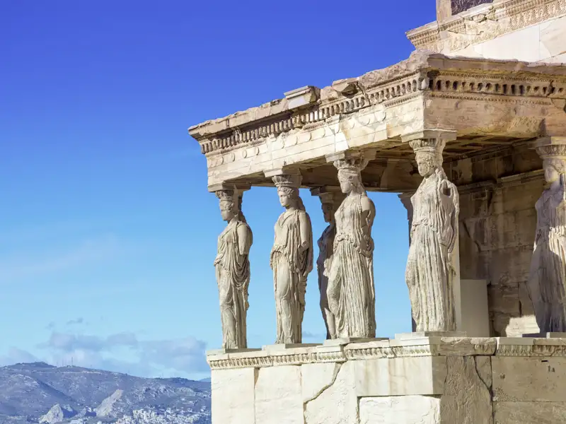 Marmorstatuen der Akropolis in Athen vor blauem Himmel
