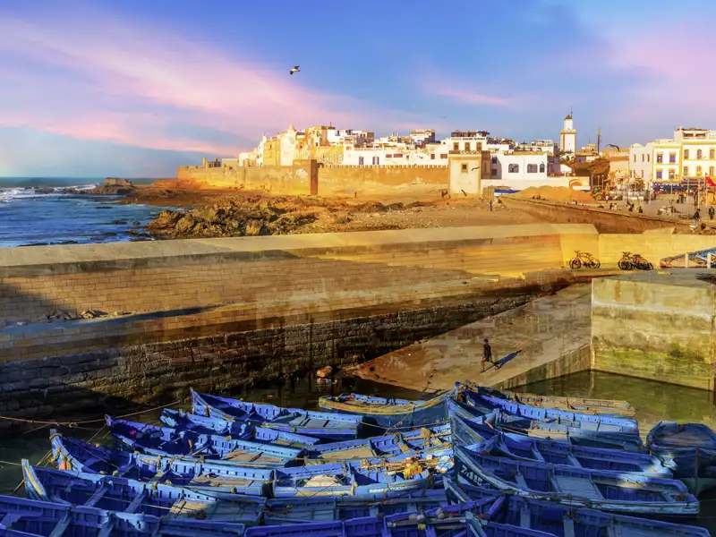 Blick auf die historische Stadt Essaouira vom Hafen mit vielen bunten Fischerbooten.